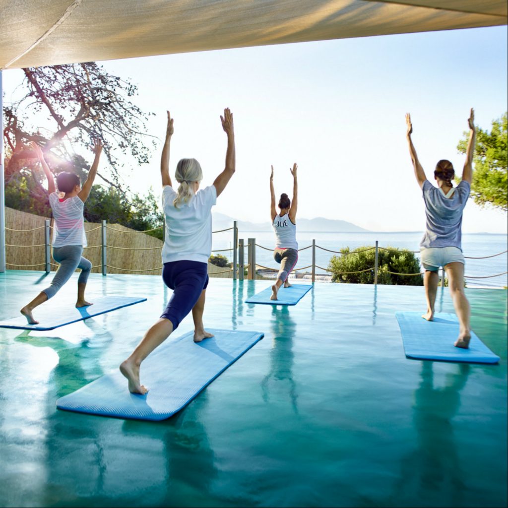 Group doing yoga with a view of the sea