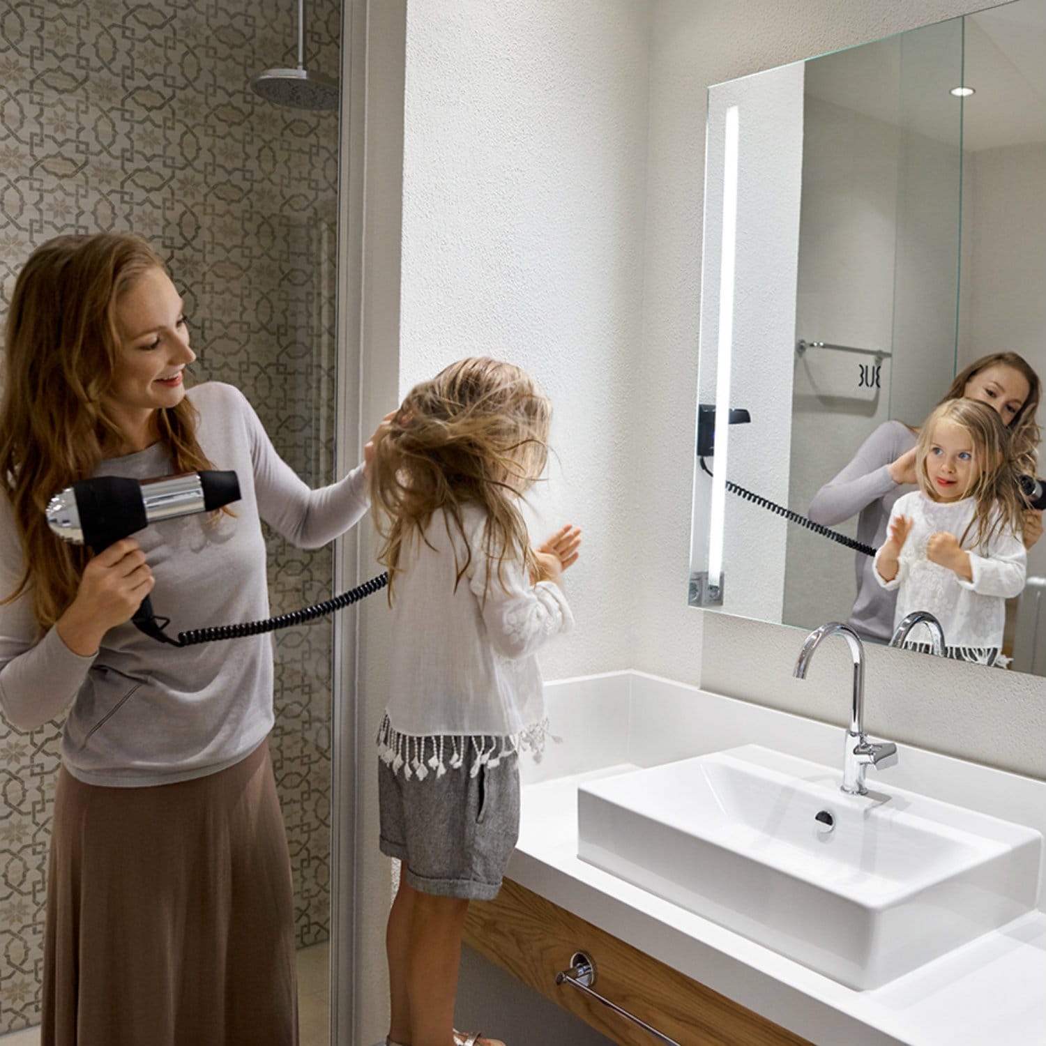 Woman blow-dries girl's hair in Farewell Lounge